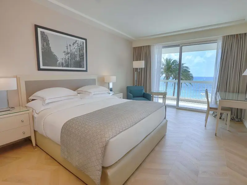 Une chambre lumineuse avec un grand lit et une vue sur la mer.