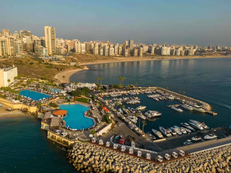 Vue aérienne d'un complexe hôtelier avec piscine et marina.