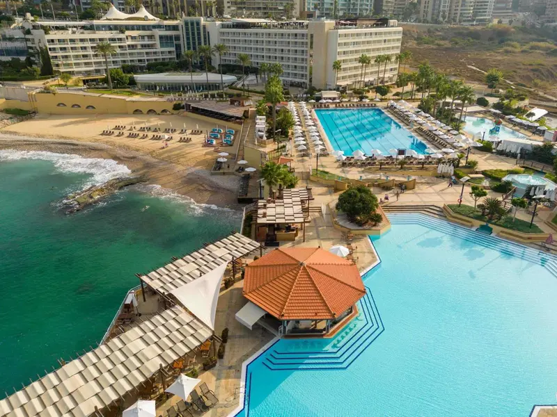 Vue aérienne d'un complexe hôtelier avec piscine et accès à la plage.