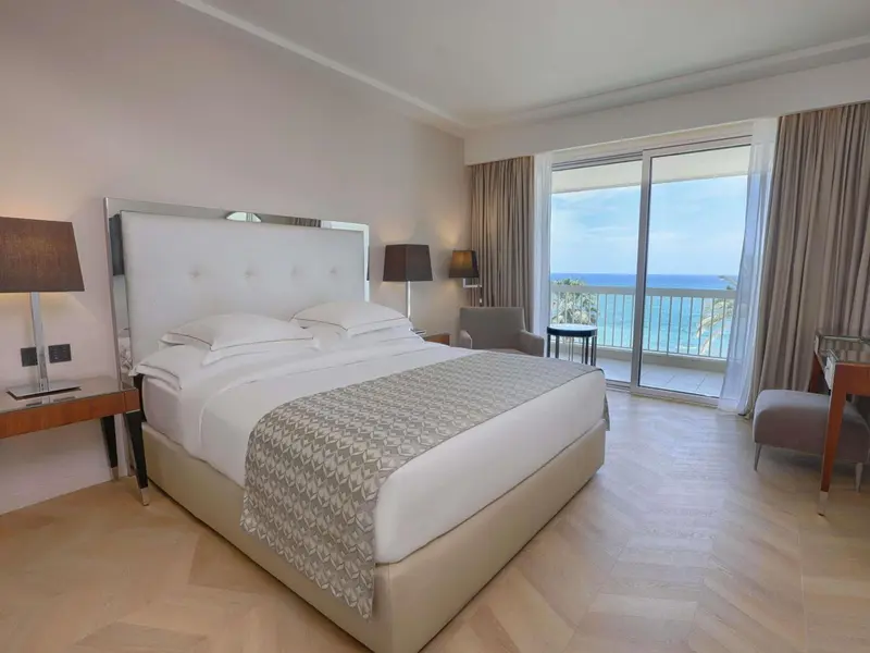 Une chambre lumineuse avec un grand lit et une vue sur la mer.