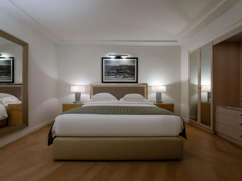 Une chambre lumineuse avec un grand lit et des tables de chevet.