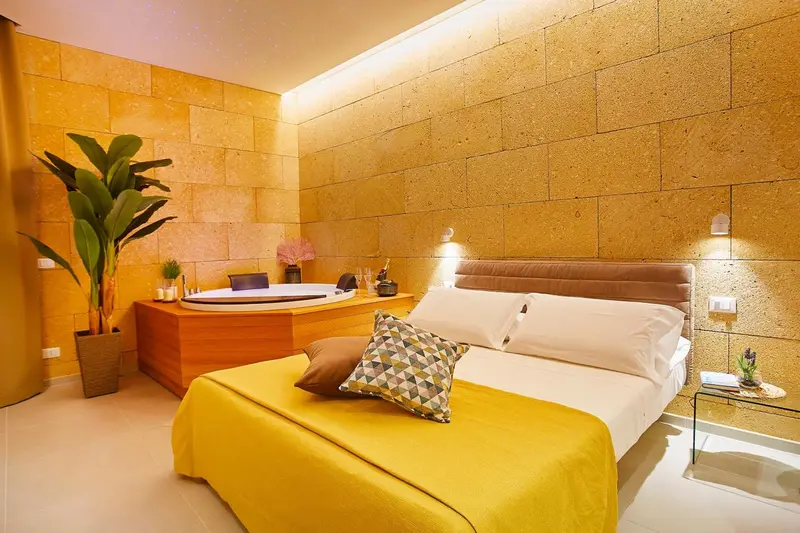 Une chambre lumineuse avec un grand lit et un jacuzzi.