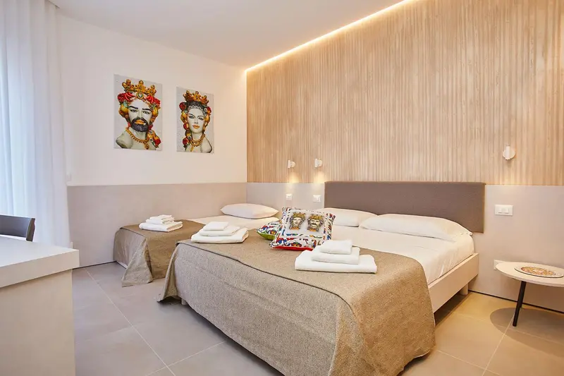 Une chambre d'hôtel moderne avec un grand lit et des œuvres d'art murales.
