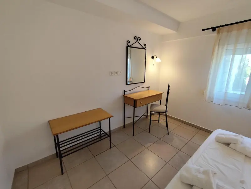 Une coiffeuse en bois et une petite table basse se trouvent dans une chambre lumineuse.