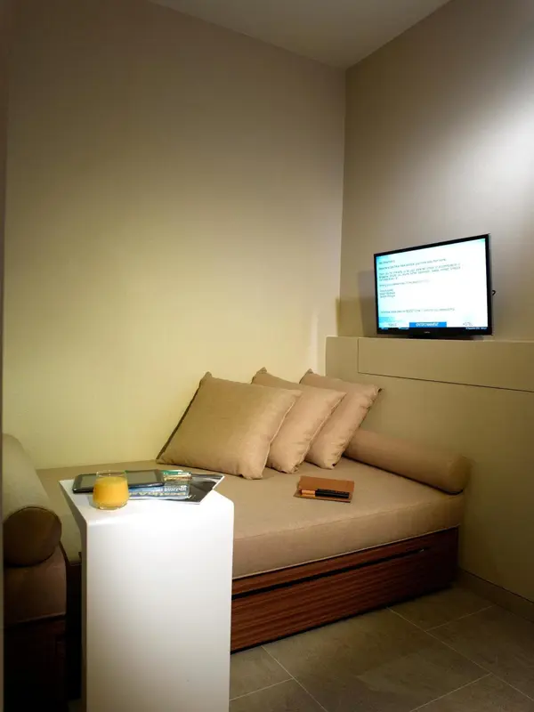 Espace de détente avec canapé intégré et téléviseur mural.