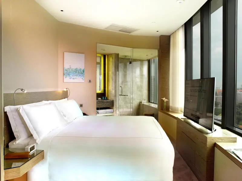 Une chambre moderne avec un grand lit et une salle de bain ouverte.