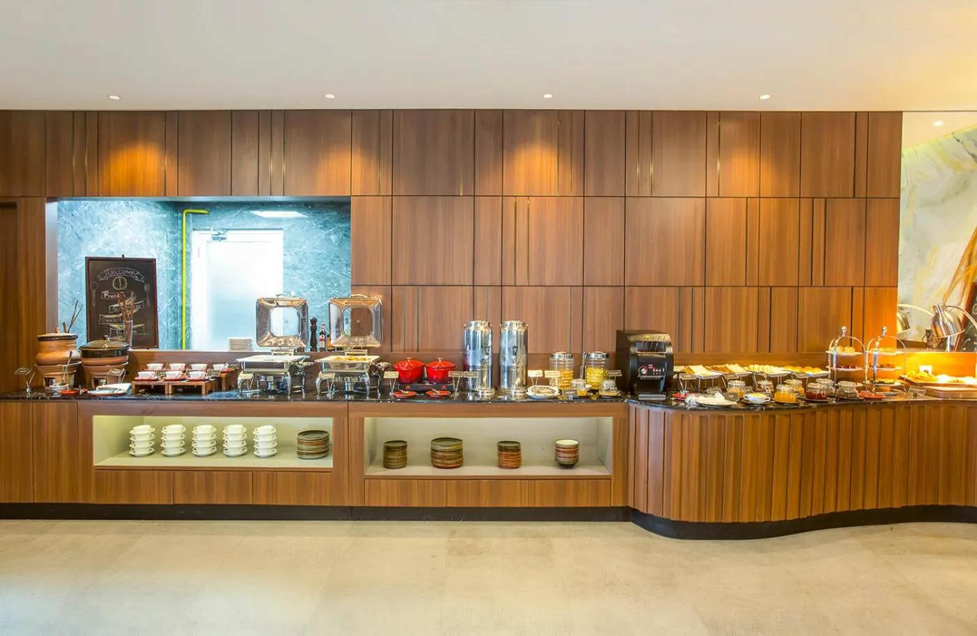 Un buffet propose une variété de plats et de boissons dans un espace lumineux.