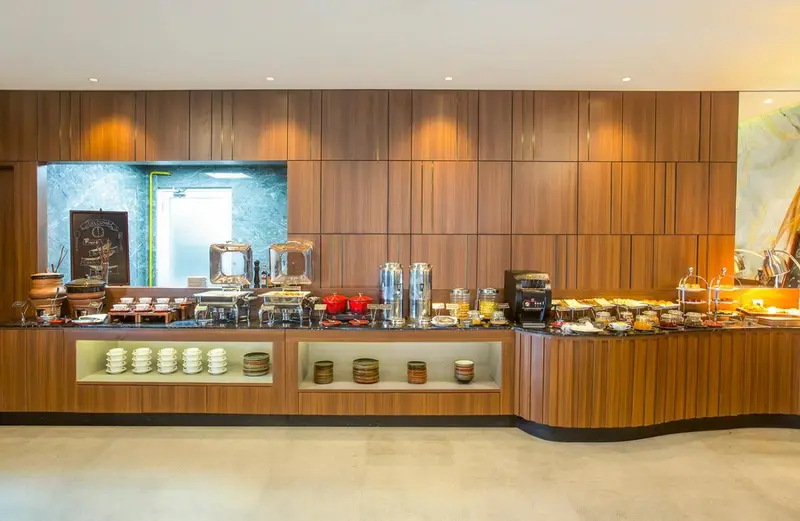 Un buffet propose une variété de plats et de boissons dans un espace lumineux.