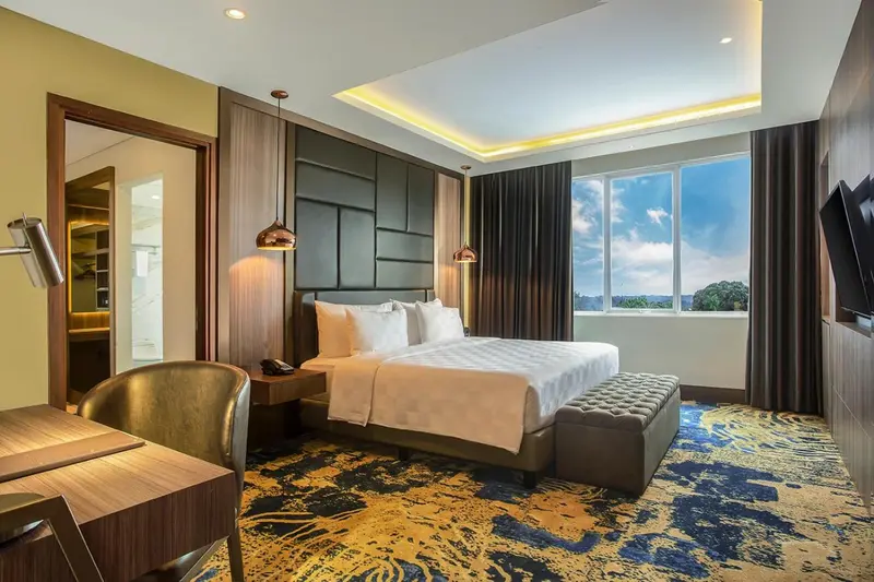 Chambre moderne avec un grand lit et une fenêtre lumineuse.