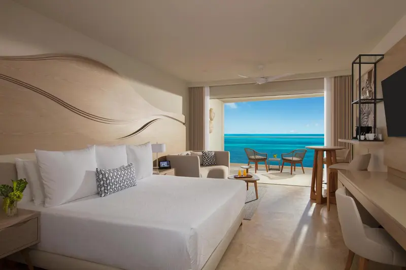 Une chambre lumineuse avec un grand lit et une vue sur la mer.