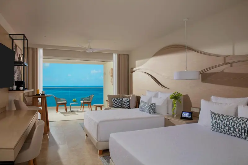 Une chambre lumineuse avec vue sur la mer turquoise.