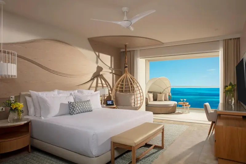 Une chambre lumineuse avec un grand lit et une vue sur la mer.