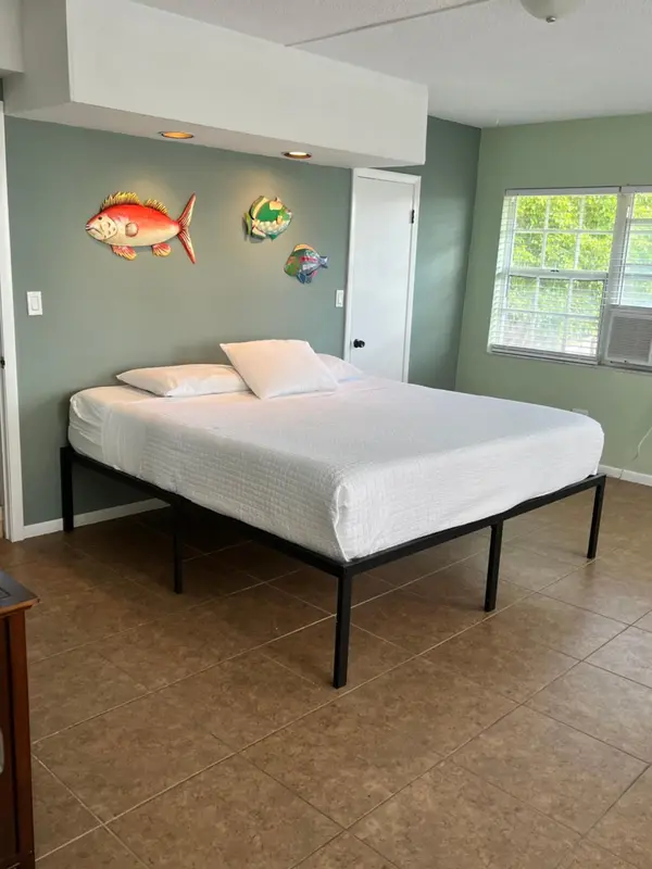 Une chambre lumineuse avec un lit simple et une décoration marine.