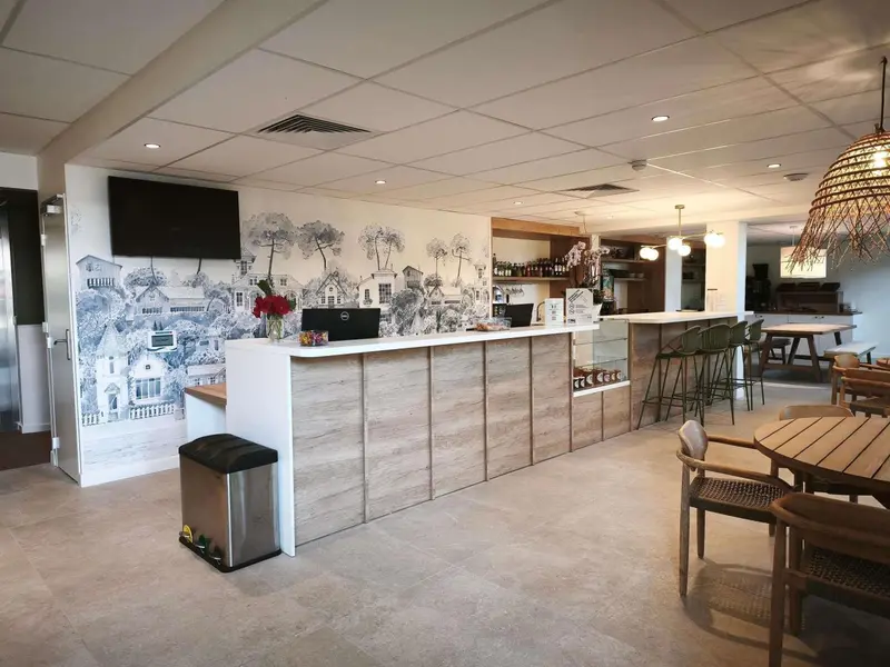 Un comptoir d'accueil moderne avec une décoration murale représentant un paysage urbain.