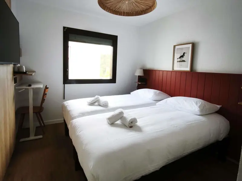 Une chambre lumineuse avec un grand lit et une fenêtre.