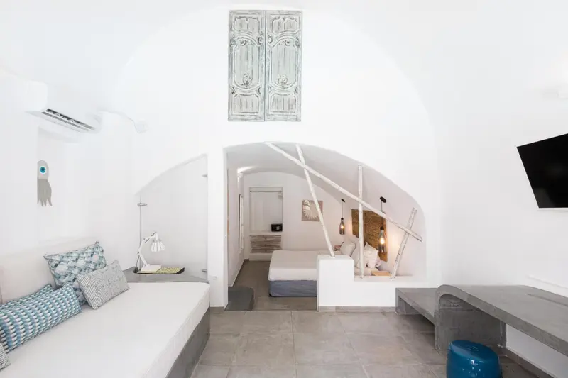 Une chambre lumineuse avec un canapé et un lit intégré dans une alcôve.