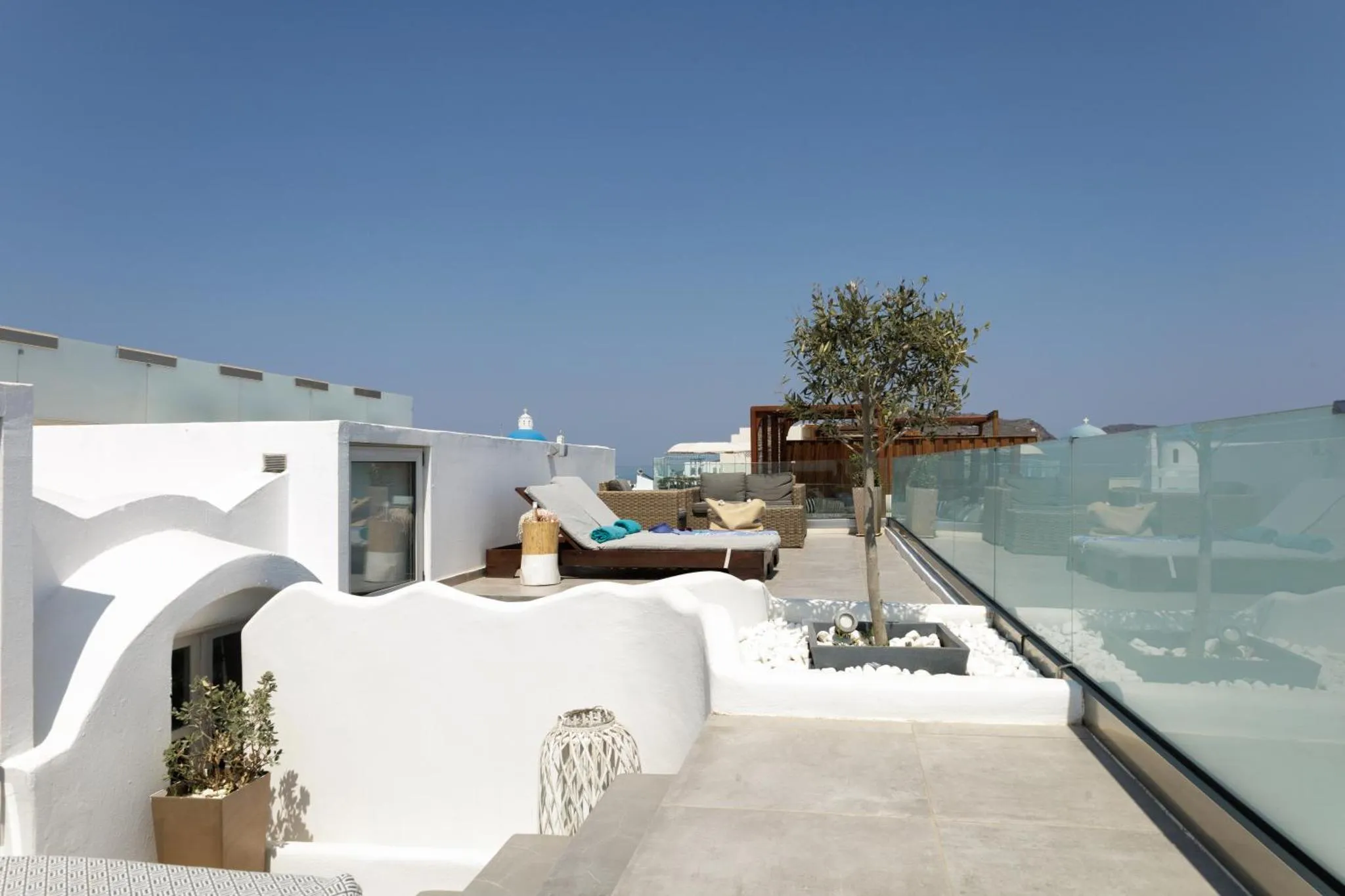 Terrasse aménagée avec transats et vue sur la mer.