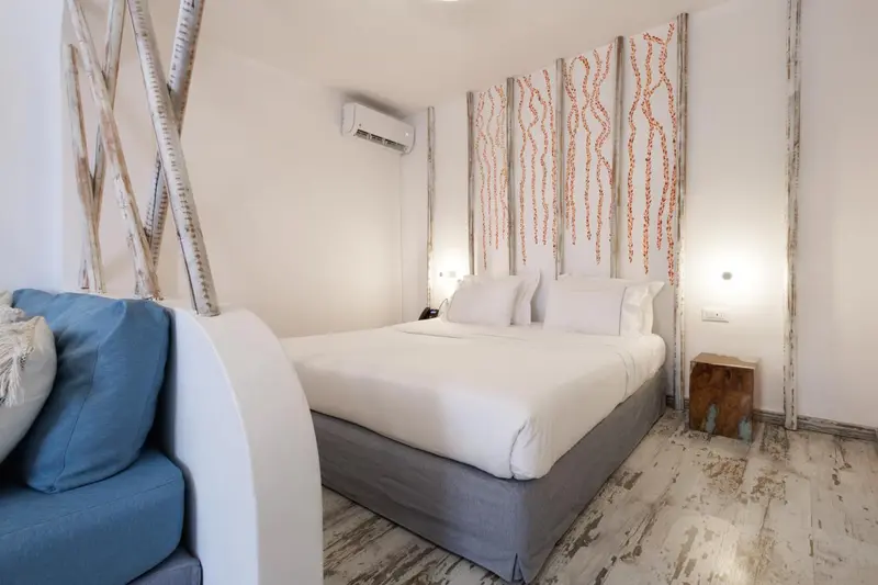 Une chambre lumineuse avec un grand lit et un canapé bleu.