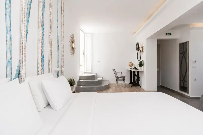 Une chambre lumineuse avec un lit fait et un espace bureau.