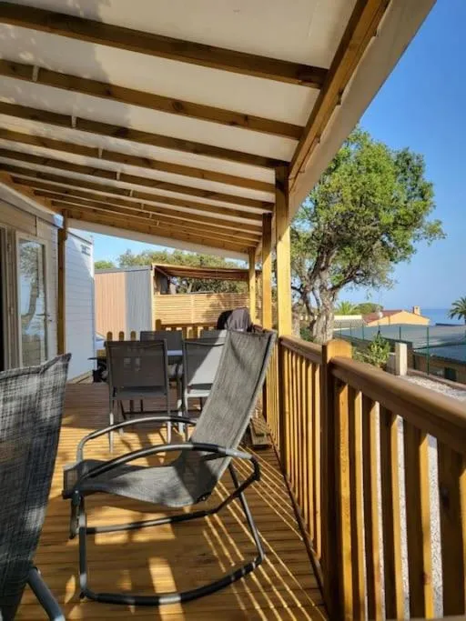 Terrasse en bois avec mobilier de jardin et vue sur la mer.
