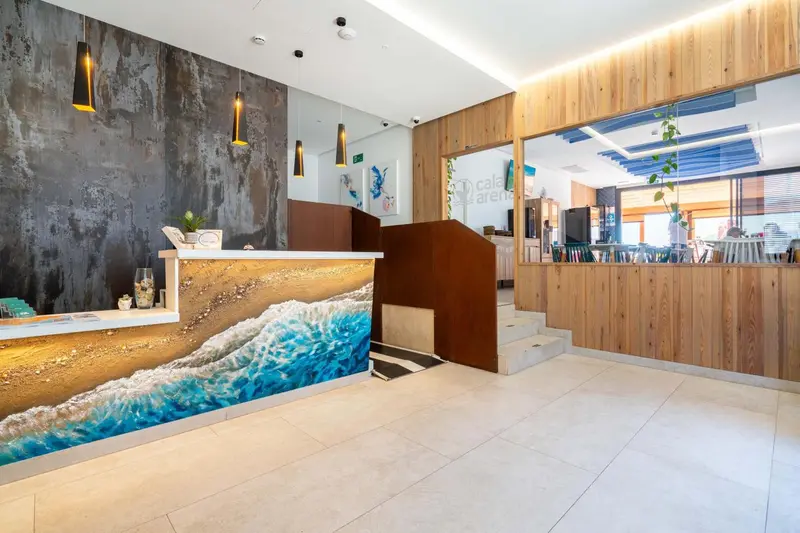 Hall d'accueil moderne avec un comptoir en bois et un mur décoré d'une scène marine.