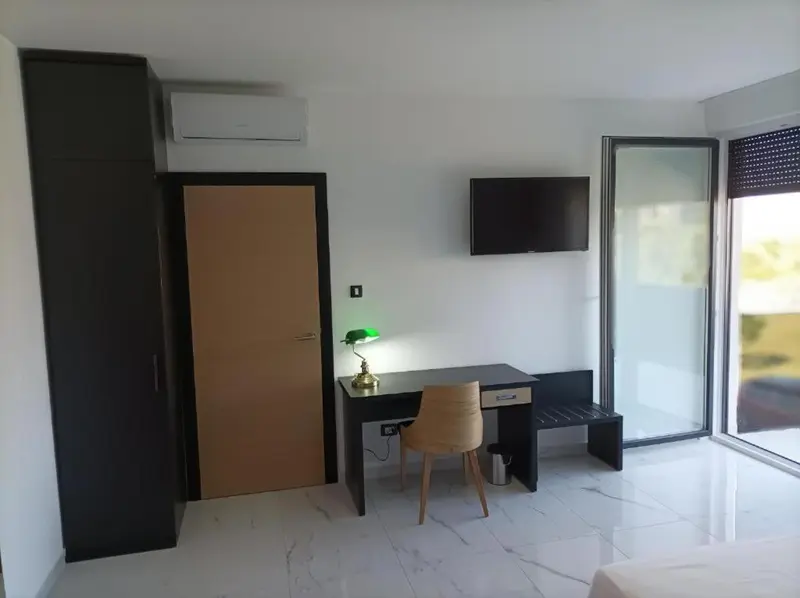 Une chambre moderne avec un bureau et une télévision murale.