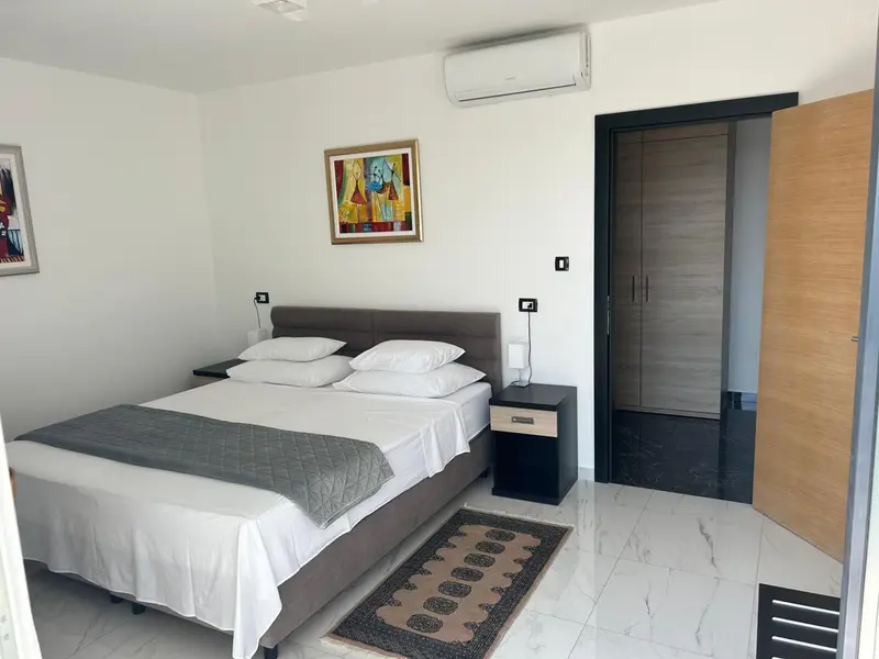 Une chambre lumineuse avec un grand lit et une décoration sobre.