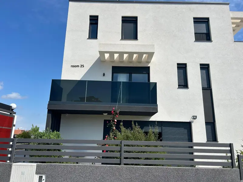 Façade moderne d'un bâtiment avec des balcons et une végétation.