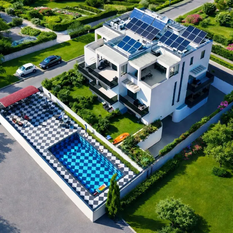 Vue aérienne d'une résidence blanche avec piscine et jardin verdoyant.
