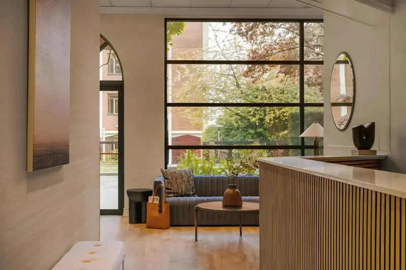 Un espace d'accueil lumineux avec un comptoir et un coin salon.