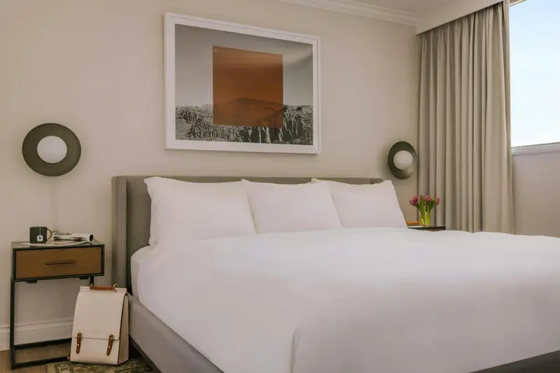 Une chambre lumineuse avec un grand lit recouvert de draps blancs.