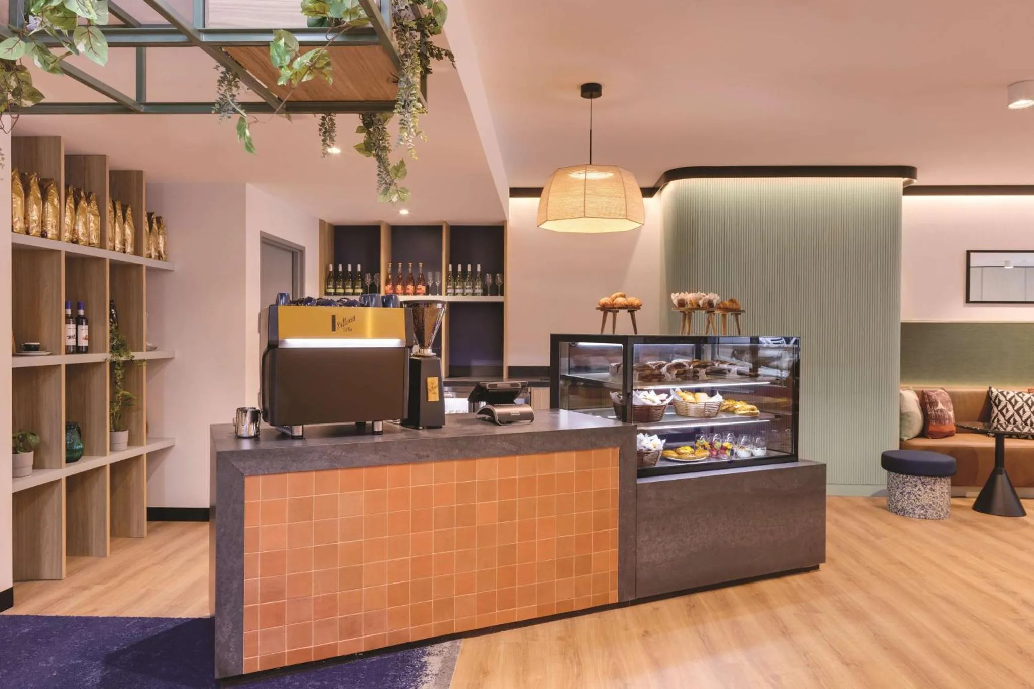 Un comptoir de café présente des pâtisseries et des boissons dans un espace lumineux et décoré.