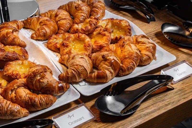 Des viennoiseries dorées sont présentées sur un plateau.