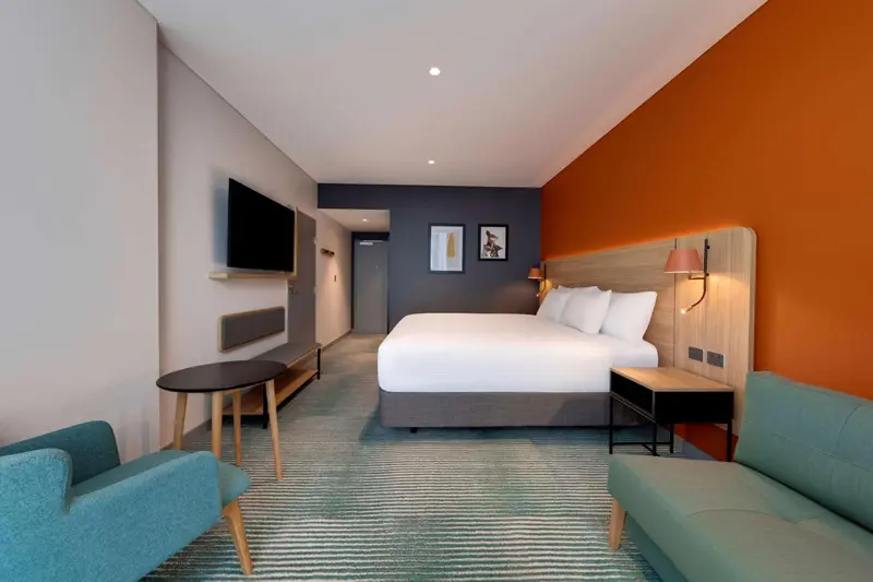 Une chambre moderne avec un grand lit et un canapé.