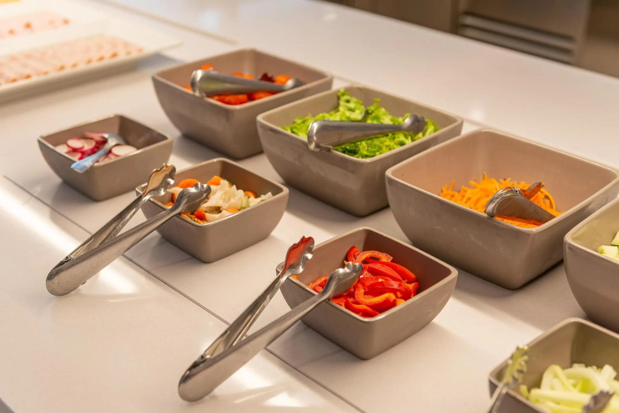 Présentation de salades fraîches et colorées sur un buffet.