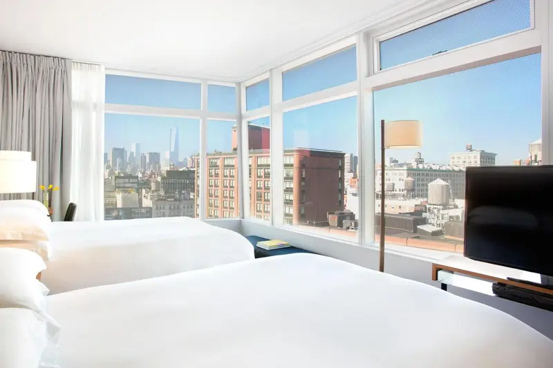 Chambre lumineuse avec vue sur la ville.