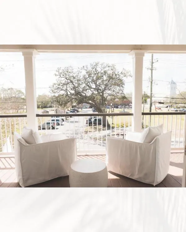 Deux fauteuils blancs invitent à la détente sur une terrasse ensoleillée.