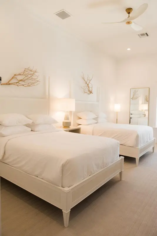 Chambre lumineuse avec deux lits simples et décoration sobre.