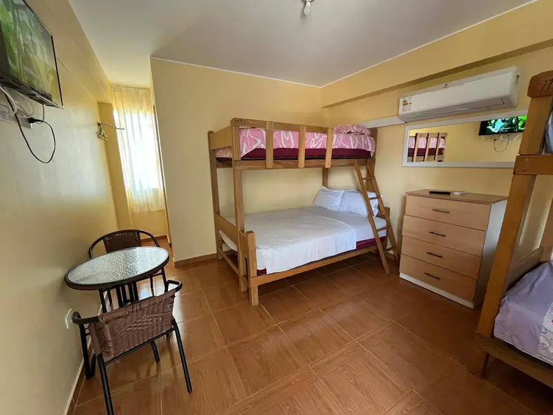Une chambre avec lits superposés et une petite table ronde.