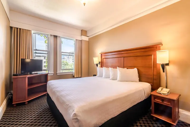 Une chambre d'hôtel lumineuse avec un grand lit et une fenêtre.