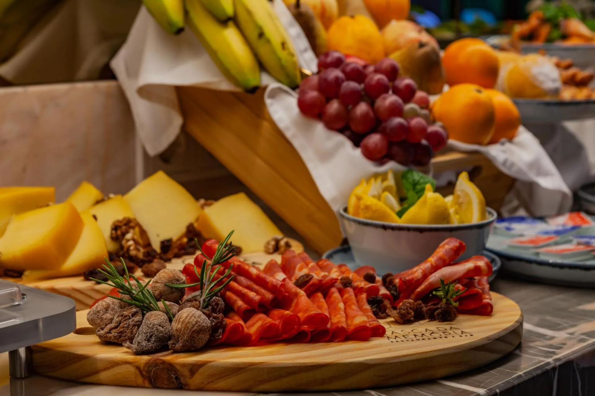 Présentation de fruits frais, de fromages et de charcuteries sur un buffet.