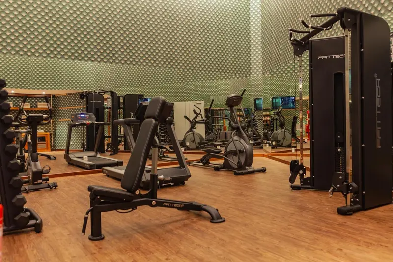 Une salle de sport lumineuse avec des équipements de musculation et de cardio.