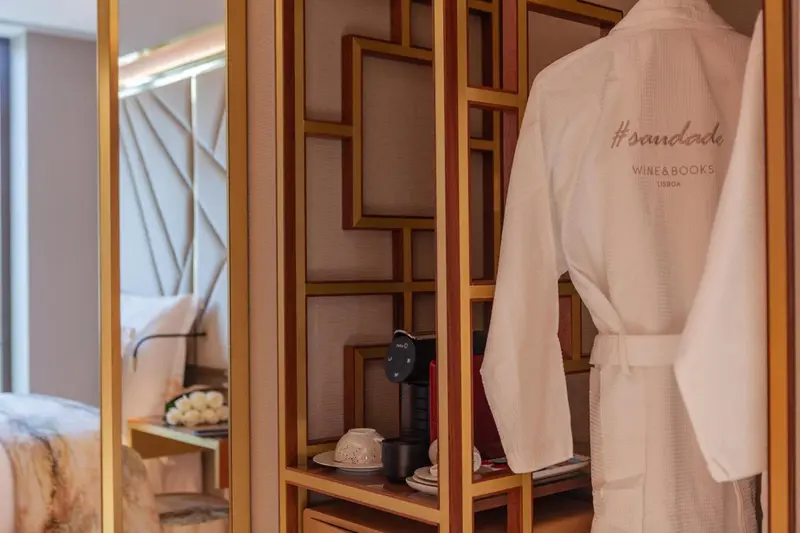 Une robe de chambre blanche est suspendue dans une chambre d'hôtel décorée de panneaux en bois.