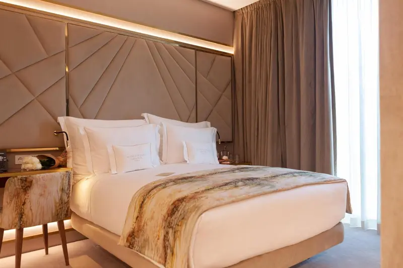 Une chambre d'hôtel moderne avec un grand lit recouvert d'une courtepointe décorative.