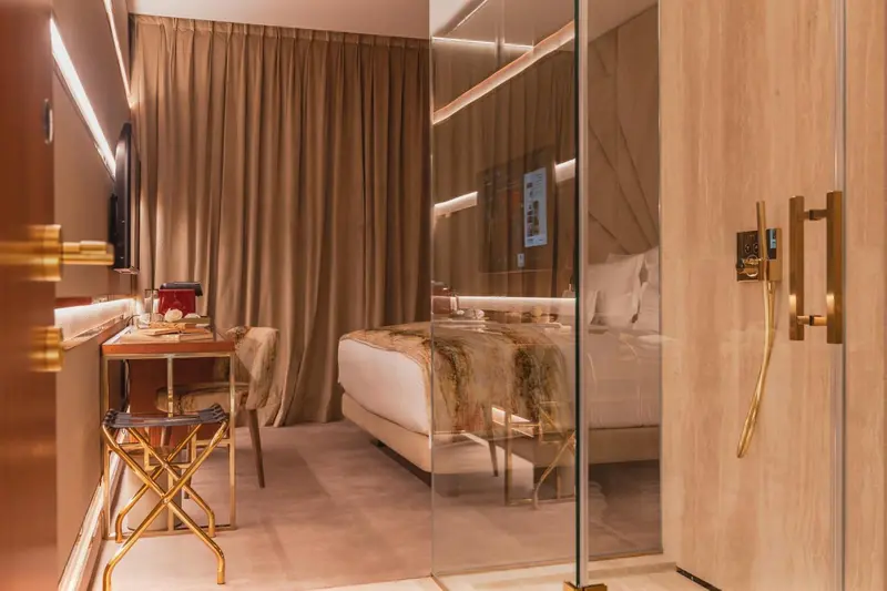 Chambre moderne avec un lit confortable et un bureau doré.