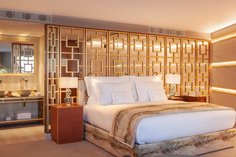 Une chambre d'hôtel moderne avec un grand lit et une décoration dorée.