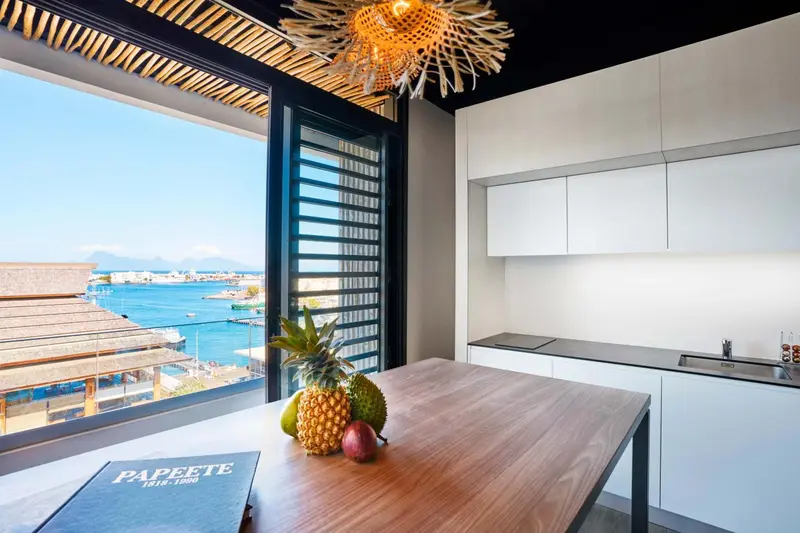 Une cuisine lumineuse s'ouvre sur une vue mer à travers de larges baies vitrées.
