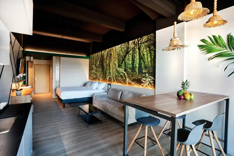 Espace de vie lumineux avec canapé, table et lit.