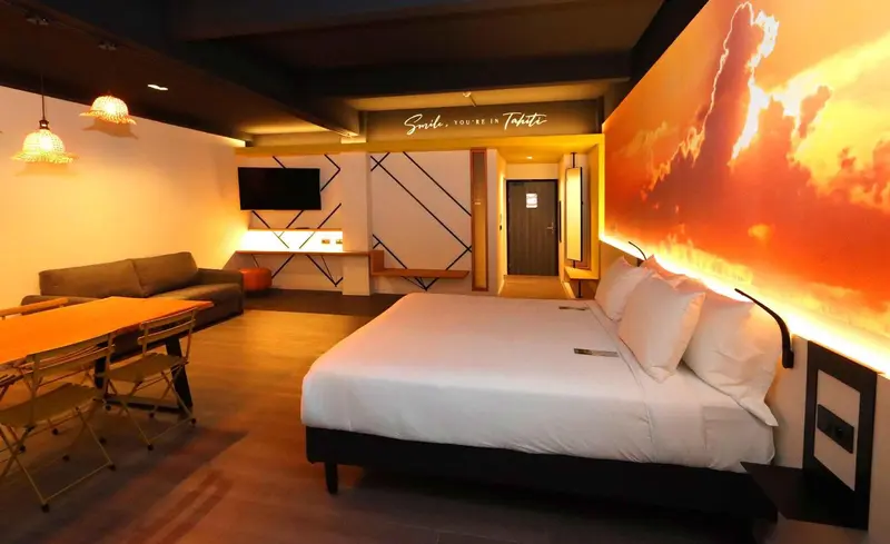 Espace de vie intérieur avec canapé, table et lit.