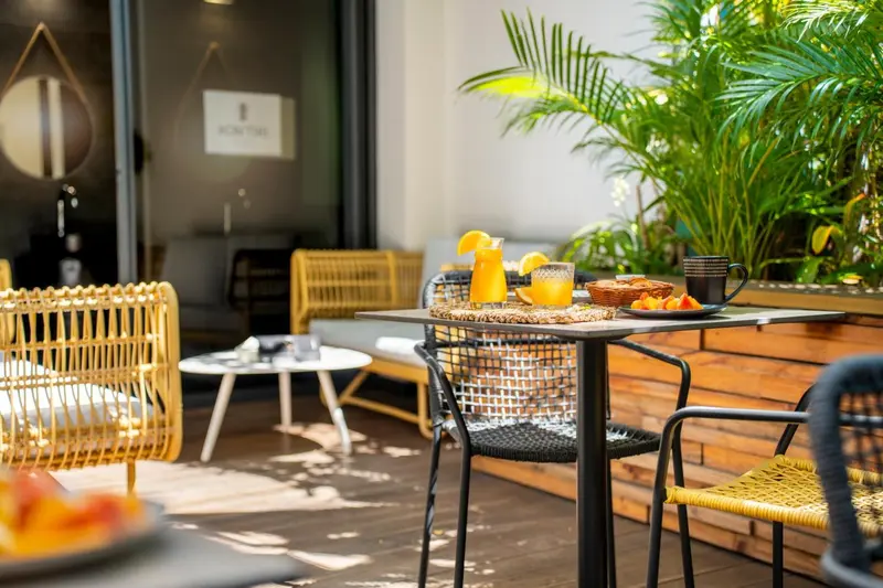 Une table avec un petit-déjeuner est mise en scène sur une terrasse aménagée.